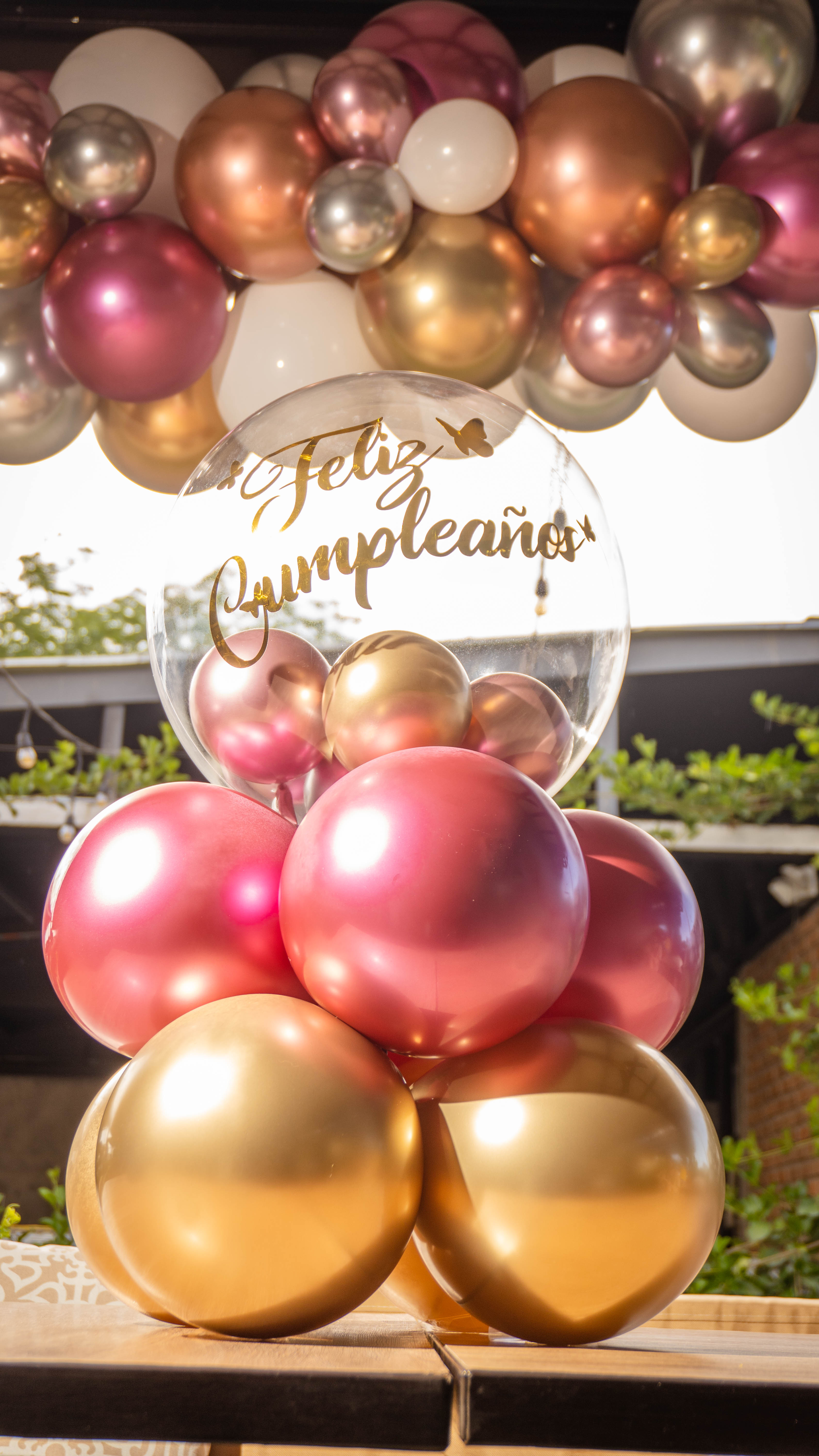 Centro de mesa con globos rosados y dorados